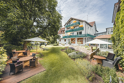 Ein Garten, im Hintergrund ein Hotelgebäude