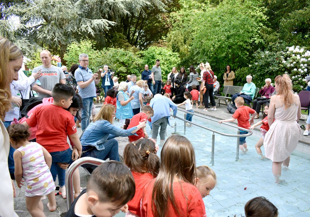 Viele Menschen, Kinder, Erwachsene, Senioren um ein Kneipp-Becken