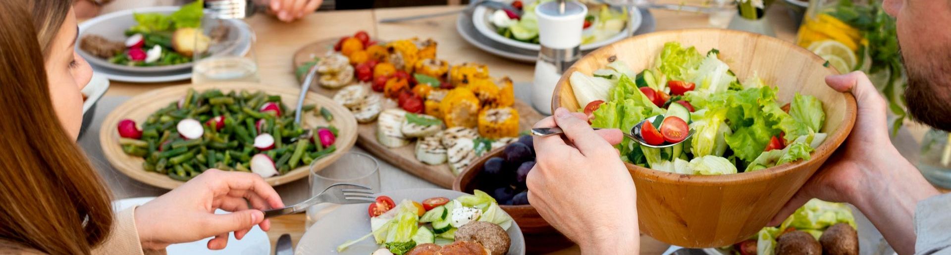 gedeckter Tisch, Hände, die essen weiterreichen