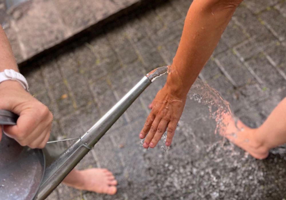 wasser aus gießkanne wird auf arme gegossen